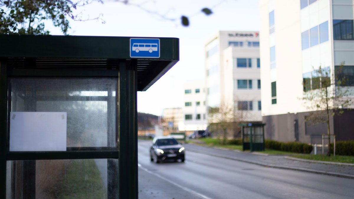 Bus stops on both sides of the road next to office buildings.